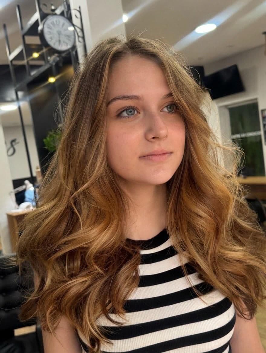 Cliente com ondas caramelo, luz natural do salão